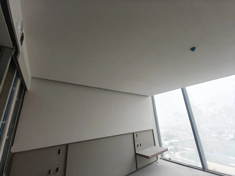 Habitación remodelada con plafón liso, muros terminados y ventanal
